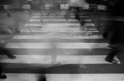 Low section of people walking on city street