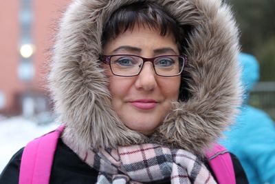 Close-up portrait of smiling woman in warm clothing