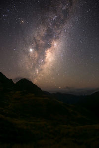 Scenic view of mountains against sky at night