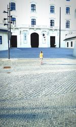 Rear view of woman walking against building