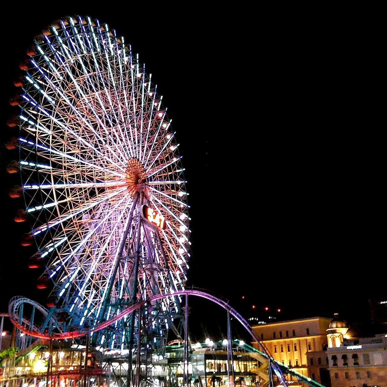 LOW ANGLE VIEW OF FERRIS WHEEL AT NIGHT