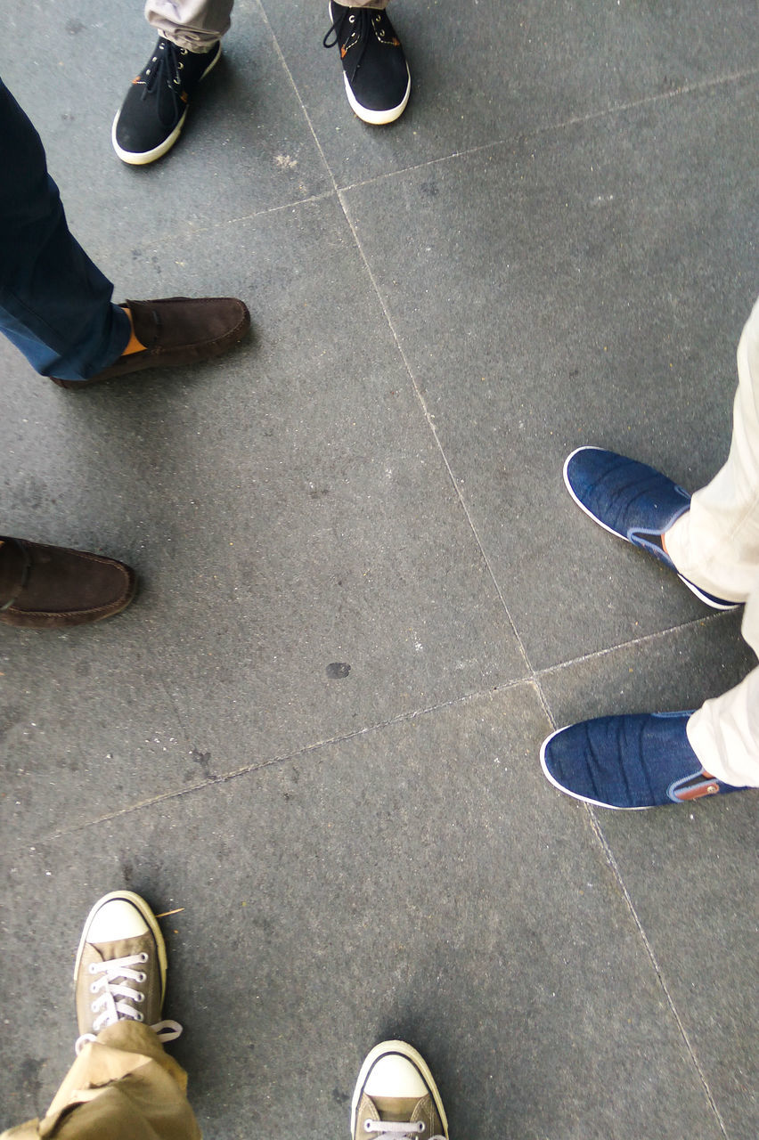 LOW SECTION OF PEOPLE STANDING ON TILED FLOOR