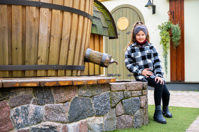 Full length portrait of smiling man holding umbrella