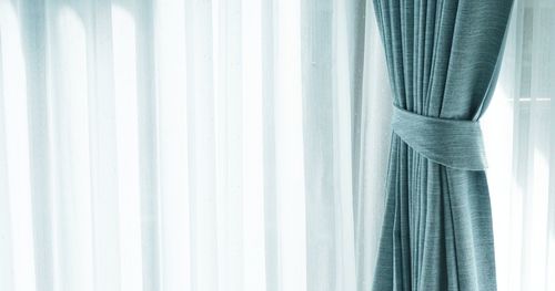 Close-up of curtain against window at home