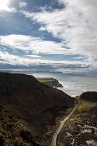 Scenic view of road by sea against sky