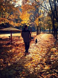 Full length of people in autumn leaves