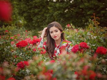 Portrait of woman with red flowers in sunlight