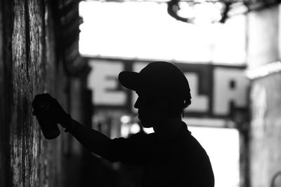 Side view of a silhouette man with spray can