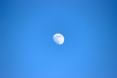 Low angle view of moon against blue sky at night