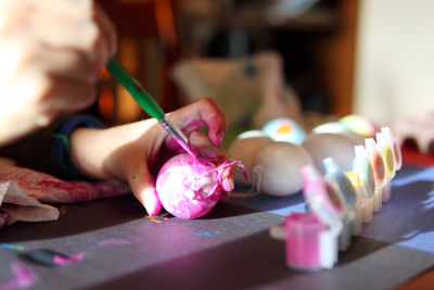 Close up of child's hands painting easter eggs at home