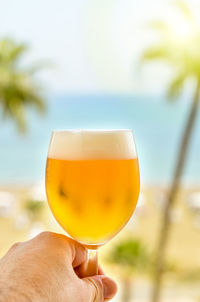 Close-up of hand holding beer glass