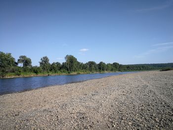 Scenic view of beach against blue sky