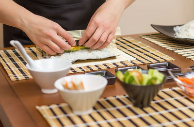 Midsection of person holding food on table