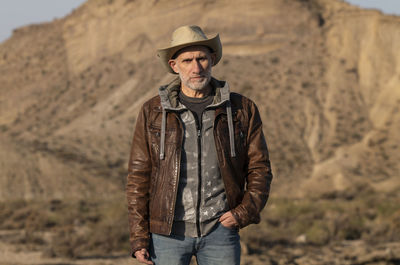 Adult man in cowboy hat looking at view of tabernas desert, almeria, spain