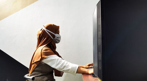 A woman wearing face mask while work from office due to covid-19 regulations