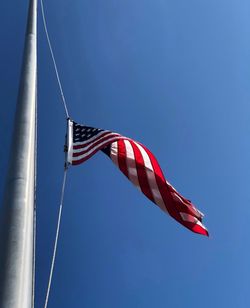 Low angle view of flag against blue sky