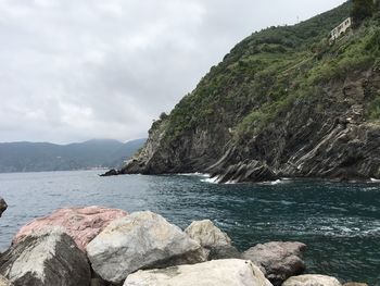 Rocks by sea against sky