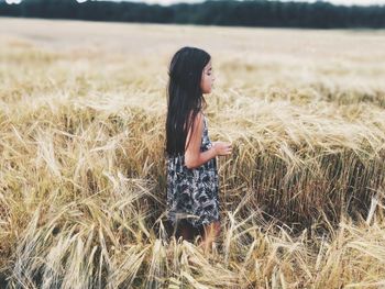 Side view of young woman standing on field
