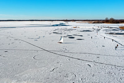 Aerial from ice sailing and skating on bergumer lake in winter in friesland the netherlands