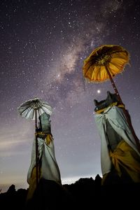 Low angle view of illuminated traditional windmill against sky at night