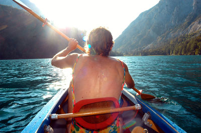 Rear view of man sitting in boat