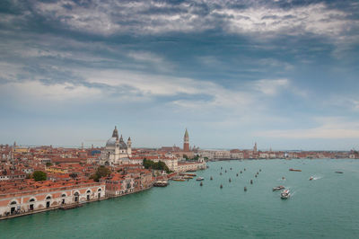 View of buildings in city against cloudy sky