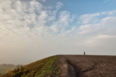 Road amidst field against sky