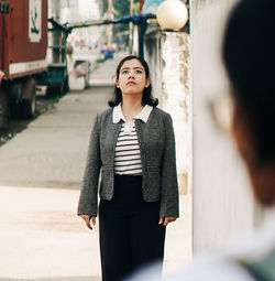 Portrait of young woman standing in city