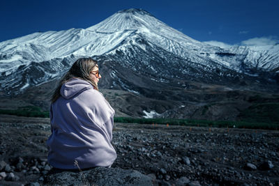 Woman on snowcapped mountain against sky