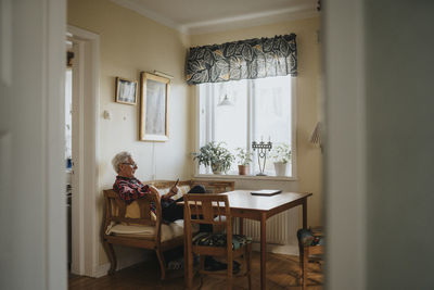 Senior man using smart phone at home