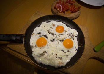 High angle view of fried egg in frying pan on cutting board at home