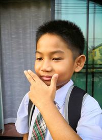 Cute boy gesturing while standing outdoors