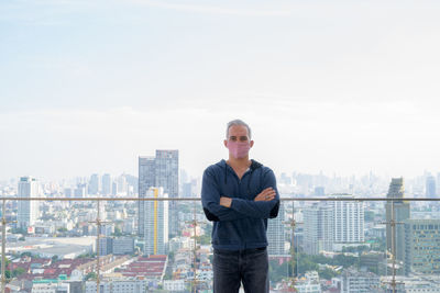 Full length of man standing in city against sky