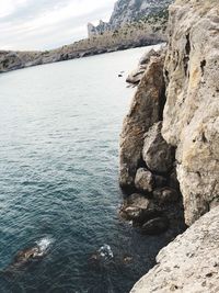 Rock formations by sea against sky