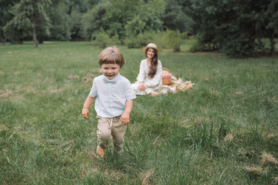 Full length of mother and daughter on grassy field