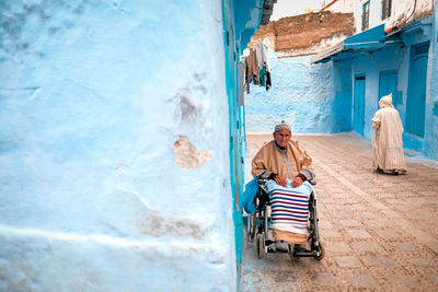 Rear view of people sitting on wall