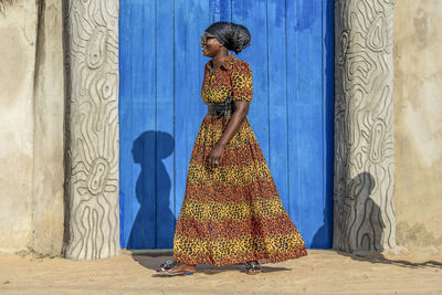 Rear view of woman standing against wall