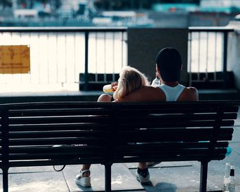 Rear view of couple sitting on bench