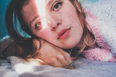 Portrait of woman lying on bed