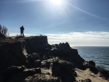 Silhouette of person standing on beach against sky