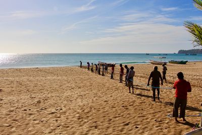 People at beach against sky