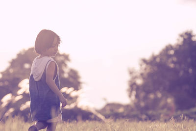 Boy on field against clear sky