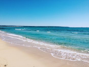 Scenic view of beach against blue sky