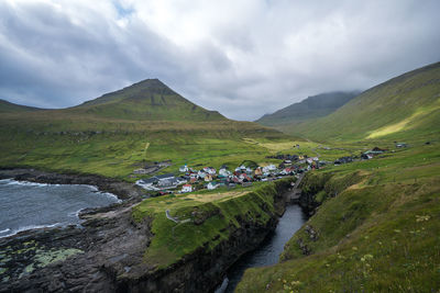 Scenic view of river by mountains against sky