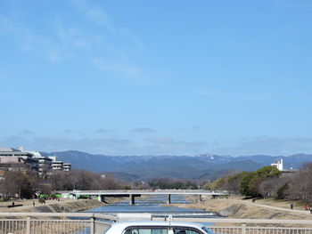 Scenic view of river by mountains against sky