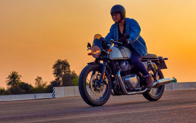 On the route to a summer vacation on a motorcycle, on an asphalt highway, a biker dude wearing.