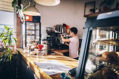 Female barista making coffee while working in cafe