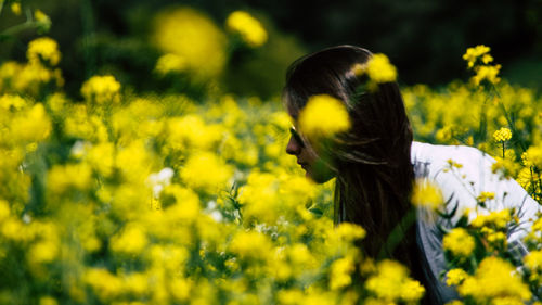 Close-up of young woman with yellow flowers