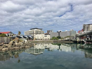 Reflection of buildings in water against sky