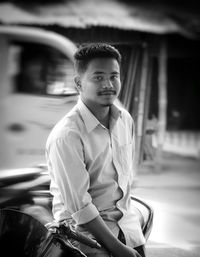 Portrait of smiling young man sitting on motorcycle